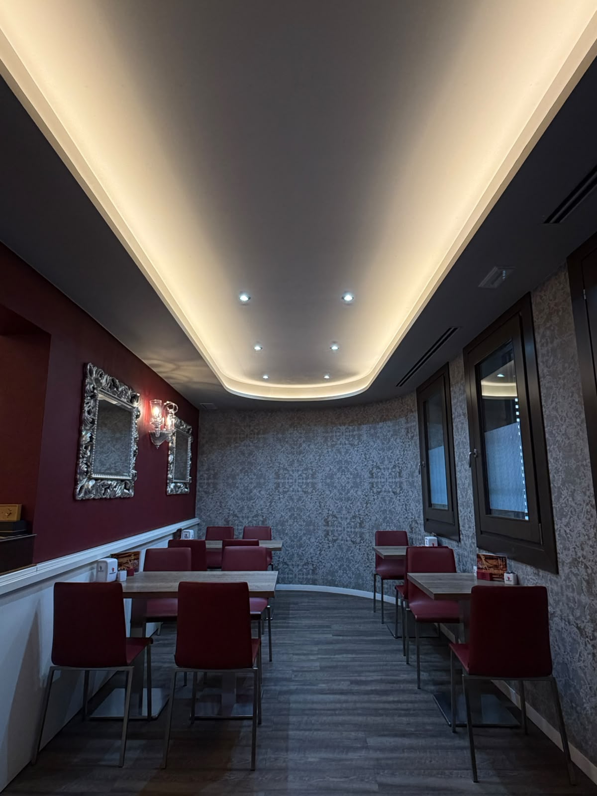 La sala interna del Caffè Palladio con tavoli e sedie bordeaux